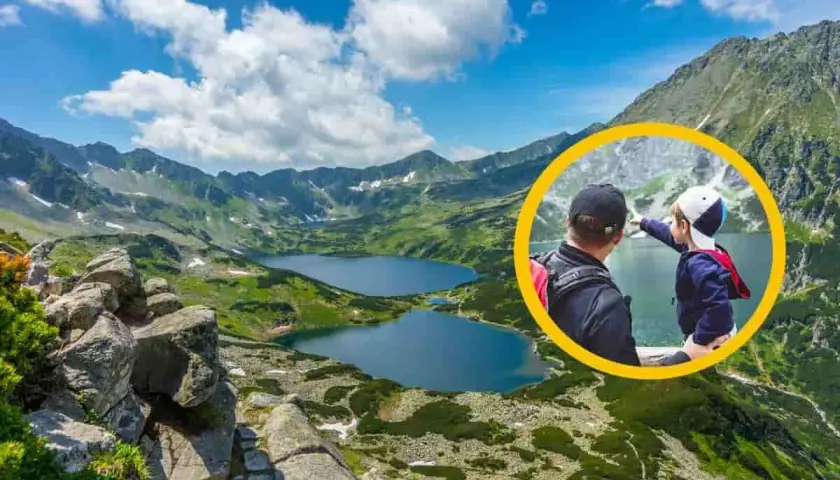 Ojciec i dziecko na szlaku w Dolinie 5 Stawów. Chłopiec wskazuje na jezioro, podziwiając górski krajobraz.