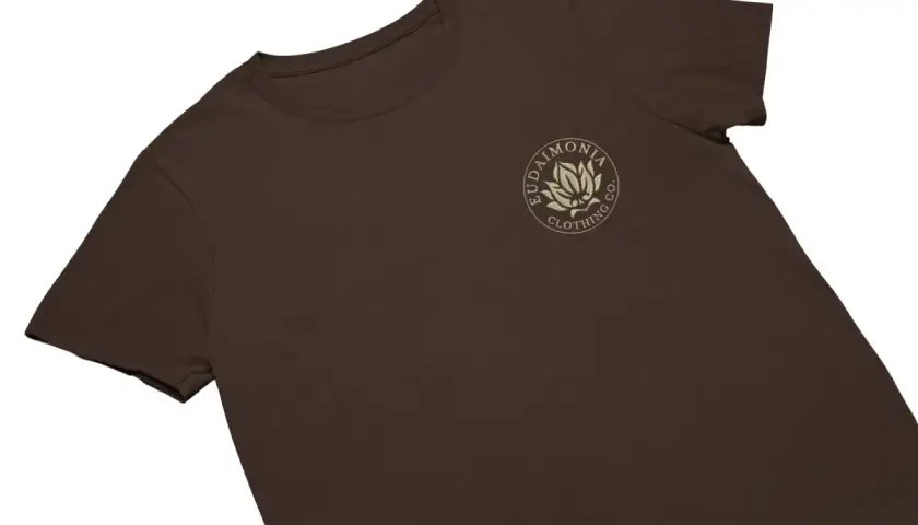 T-shirt marron avec un logo brodé d'une fleur de lotus et du texte "Eudaimonia Clothing Co.".