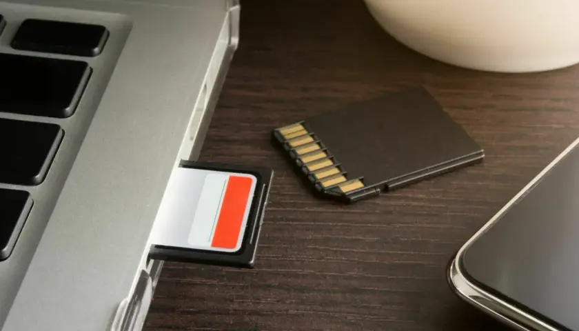 SD-Karte wird nicht erkannt in Windows 10? Ein Laptop, eine SD-Karte im Slot und eine daneben liegende Karte deuten auf ein Problem hin.