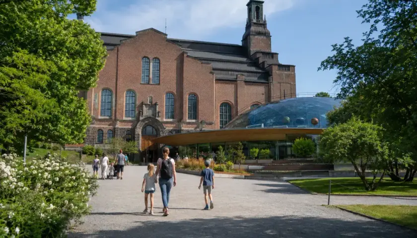 Familj promenerar mot Teknikmuseet med sin imponerande kupol.