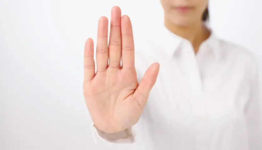 Dłoń uniesiona w geście stop. To symbol asertywności i stawiania granic.