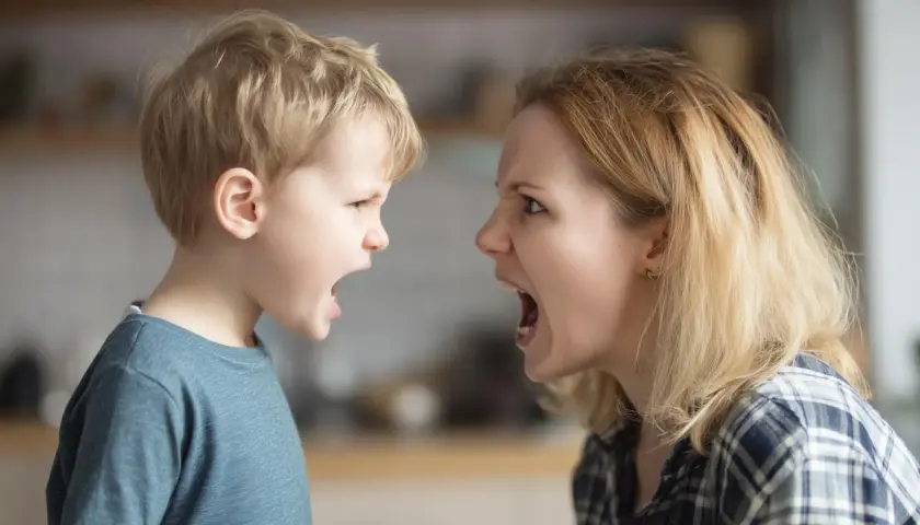 Madre e hijo se miran fijamente, ambos con la boca abierta y expresiones de enfado. ¡Qué importante es no gritar!
