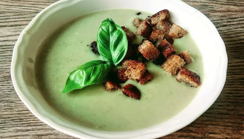 Zupa krem ze świeżych ogórków Ani gotuje się na wolnym ogniu, podana z grzankami i listkiem bazylii.