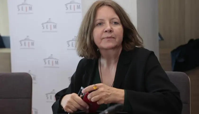 Joanna Lichocka, polityczka, siedzi przy stole. W tle logo Sejmu. Interesuje Cię, ile nieruchomości posiada Joanna Lichocka i skąd wziął się jej majątek?