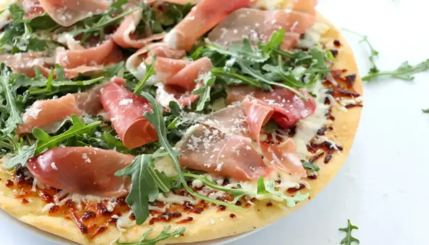 Pizza crudo z rukolą i parmezanem, pachnąca słońcem Włoch.