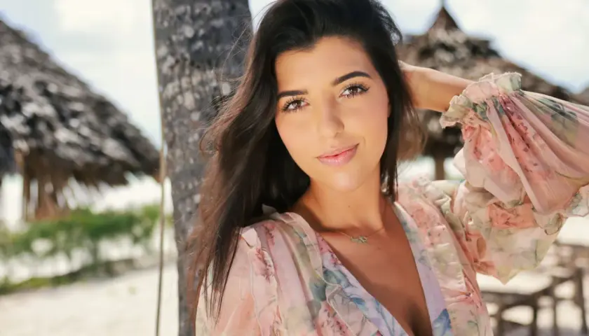 Luiza w kwiecistej sukience na plaży, czuje się jak w hotelu Paradise.