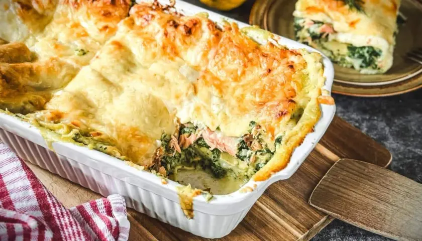 Herzhafte Spinat-Lachs-Lasagne mit goldbraun überbackener Käseschicht, bereit zum Servieren.