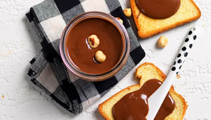 Crema di nocciole fatta in casa, vellutata e invitante, su fette di pane tostato. Un piacere da gustare!