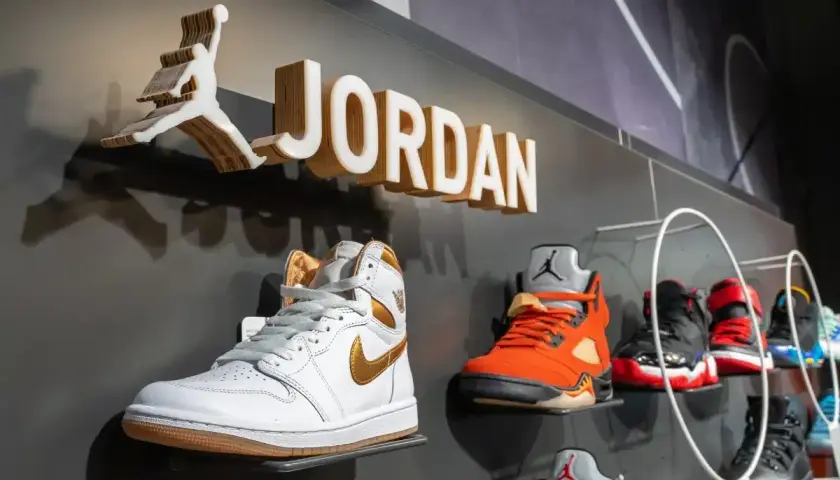Na ścianie widnieje logo Jordan i nazwa marki. Na półkach wyeksponowane są kultowe buty Jordan Air w różnych kolorach.