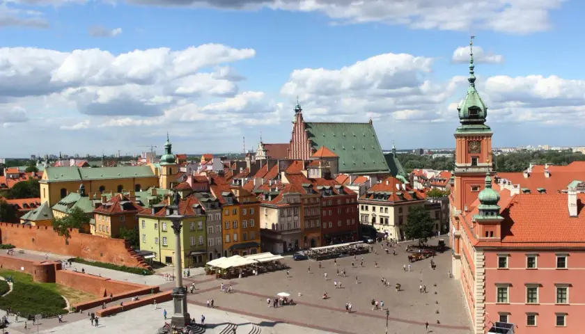 Widok na Zamek Królewski i Rynek Starego Miasta w Warszawie. Kolorowe kamienice, kolumna Zygmunta i tłumy turystów.