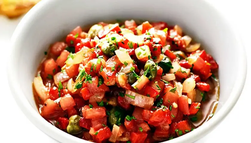 En skål med färsk salsa, perfekt för ditt salsa recept. Tomater, lök och örter blandas till en läcker röra.