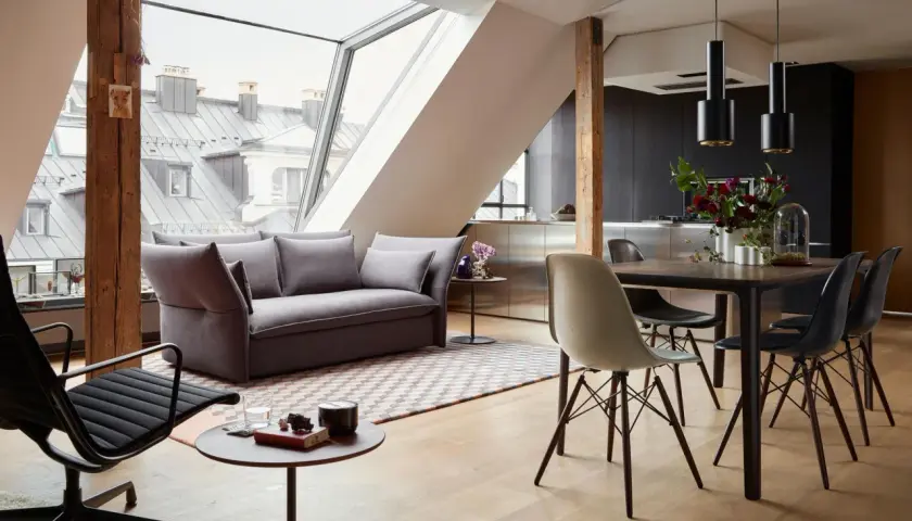 Modernes Wohnzimmer mit Dachfenster: Hier lässt sich Sofa und Esstisch gut kombinieren. Graues Sofa, Holzboden, schwarzer Esstisch mit Stühlen.