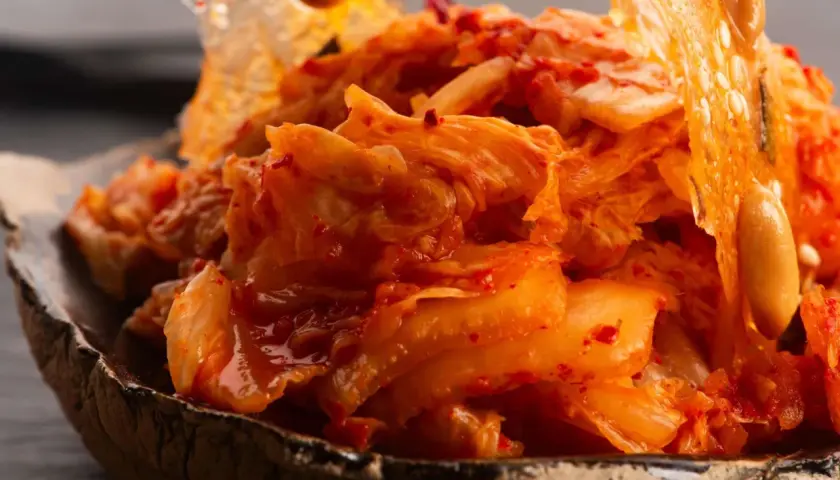 Nahaufnahme von würzigem, fermentiertem Chinakohl, der in einer Schüssel serviert wird. Dieses kimchi ohne fischsauce ist ein Genuss für Veganer.