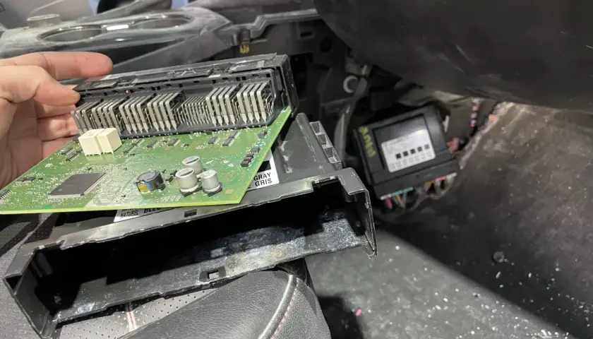 Naprawa modułu komfortu w Oplu, błąd dtc u0140. Widoczna zielona płytka drukowana z elementami elektronicznymi.