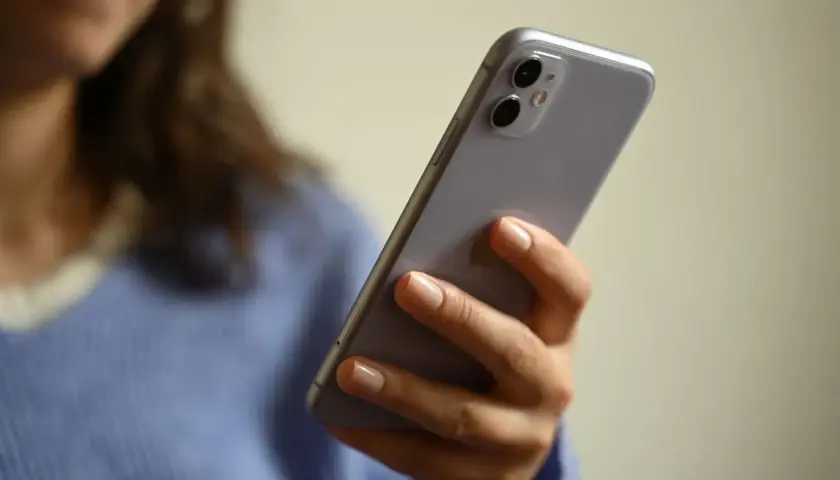 Frau hält Handy, fragt sich: "Angeblich Lotto-Abo abgeschlossen, was tun?