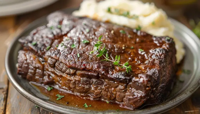 Un paleron de bœuf braisé, tendre et juteux, servi avec une purée de pommes de terre crémeuse et garni de thym frais. Un délice réconfortant.