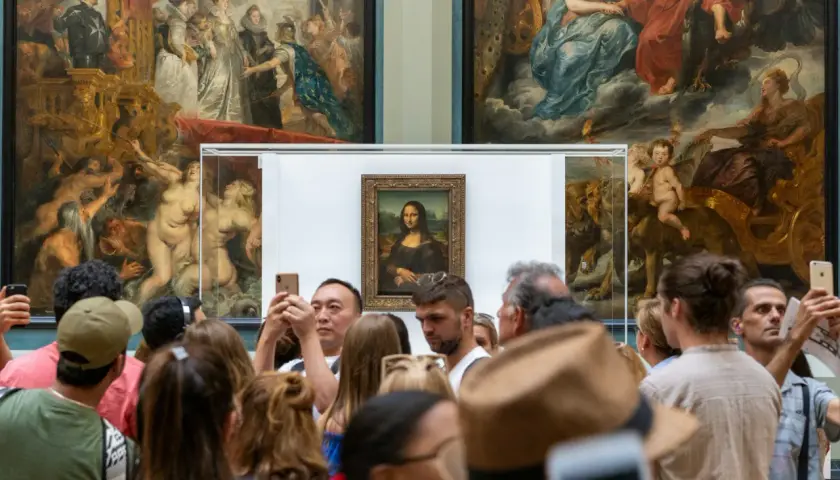Tłum ludzi ogląda Mona Lisę, dzieło renesansu, w muzeum.