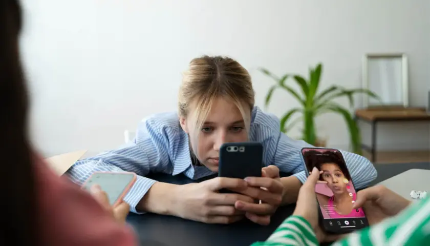 Młodzi ludzie pochłonięci smartfonami, być może doświadczający nomofobii. Co to za zjawisko?