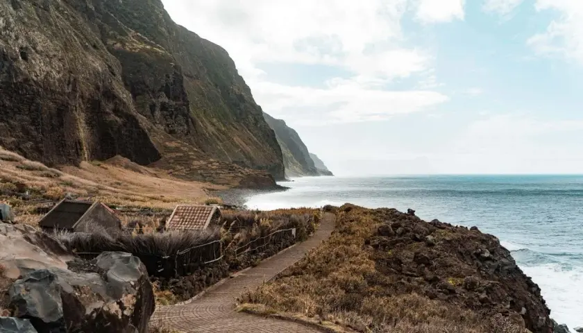 Steile Küsten und das Meer: Hier kann man auf Madeira wandern und die Natur genießen. Kleine Häuser am Wegrand laden zum Verweilen ein.