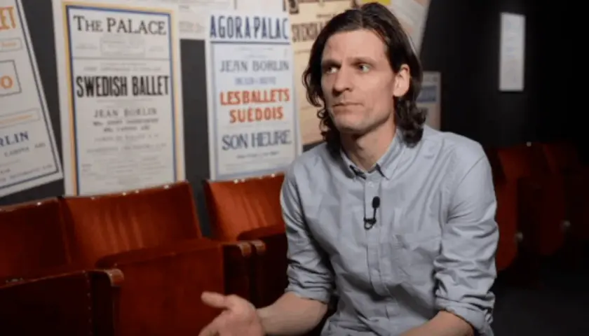 Erik Mattsson vid Dansmuseet, omgiven av affischer för Swedish Ballet och Les Ballets Suédois.