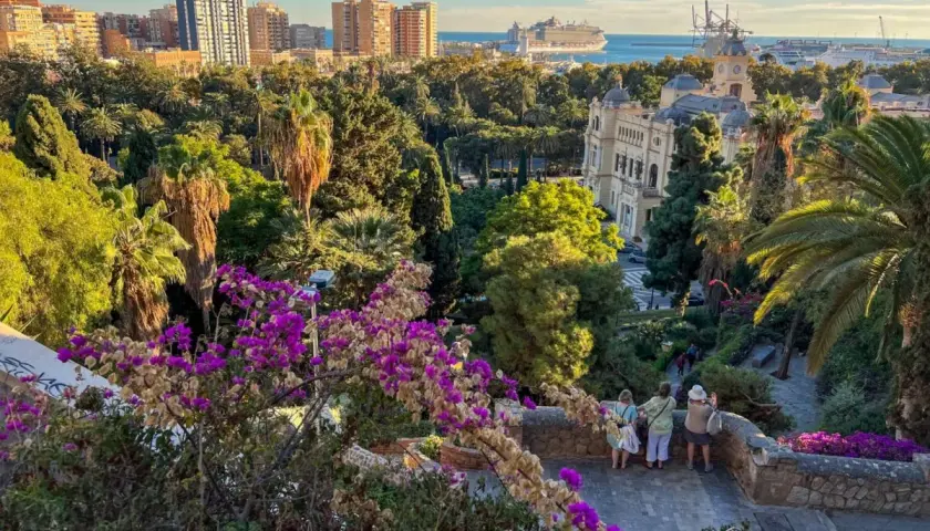 Malaga zwiedzanie: widok na park z palmami, budynki i port z rejsem. Spacer po urokliwych zakątkach miasta.