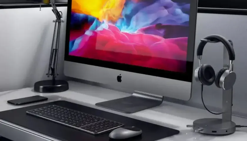 Elegancka podstawka pod słuchawki obok komputera iMac.