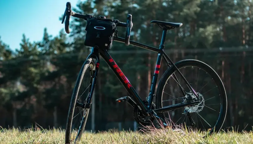 Czarny rower gravelowy z sakiewką na kierownicy, gotowy na wyprawę wzdłuż rzeki Loary.