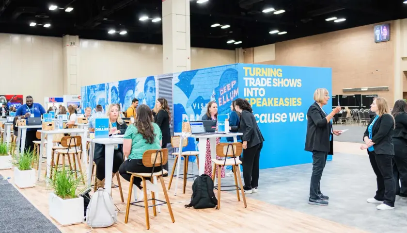 Attendees network at government trade shows, with a vibrant blue booth promoting "Turning Trade Shows Into Speakeasies.