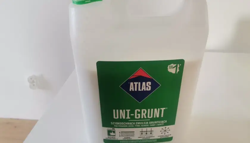 Biały kanister z zieloną nakrętką zawiera emulsję gruntującą Atlas Uni-Grunt. Idealny do przygotowania podłoża pod tynki i farby.