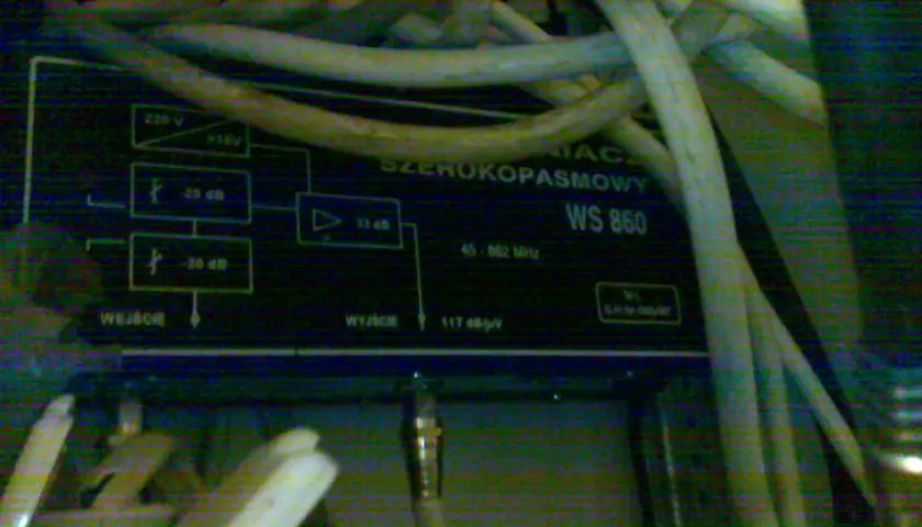 Wzmacniacz sygnału telewizji kablowej w bloku, model WS 860, z licznymi kablami.