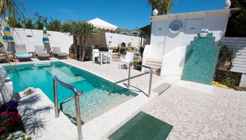 Piscina e doccia esterna in un'area relax, ideale per chi cerca "park hotel la villa ischia recensioni" per una vacanza indimenticabile.