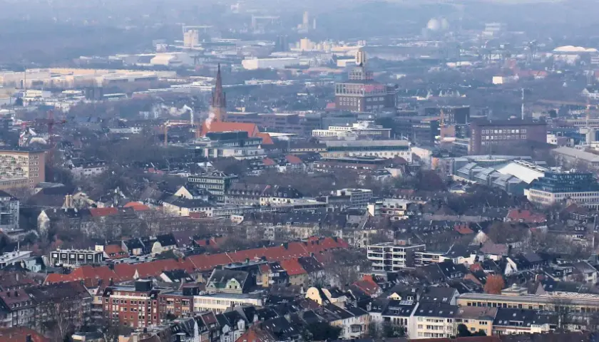 Rozległy krajobraz miejski, gdzie widać charakterystyczne budynki i dachy, tworzy obraz miasta Dortmund.
