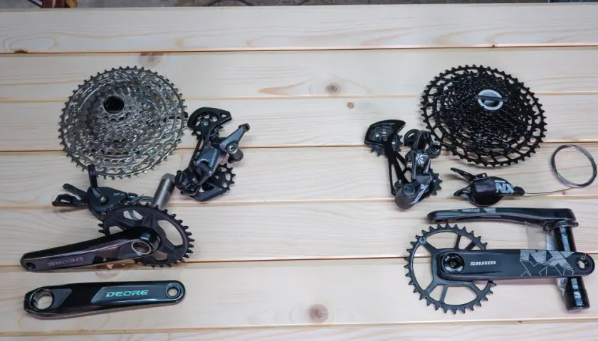 Porównanie grup osprzętu rowerowego: SRAM vs Shimano. Widoczne kasety, przerzutki, korby i manetki.