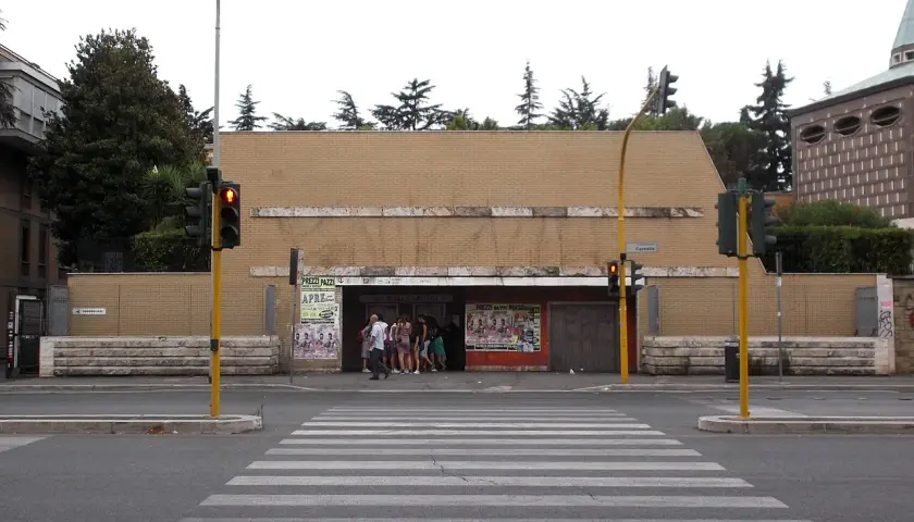Ingresso della metro Cornelia a Roma, con persone in attesa e semafori rossi.