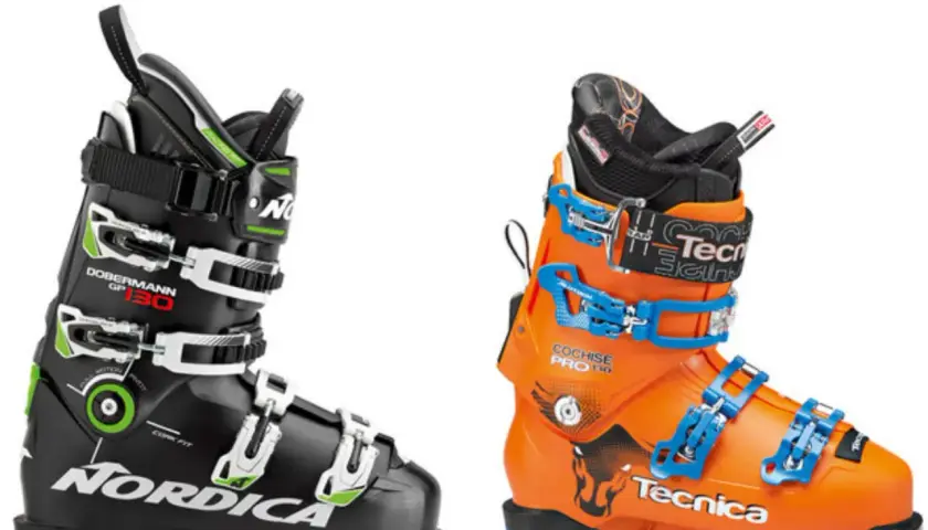 Dwa buty narciarskie: czarny Nordica Dobermann GP 130 i pomarańczowy Tecnica Cochise Pro 130. Gotowe do zapinania butów narciarskich.
