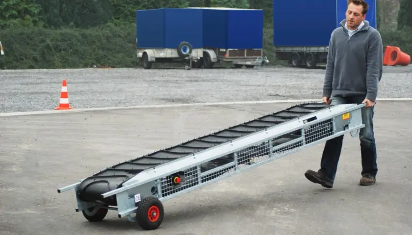 Mann trägt ein 3 Meter langes Förderband, bereit für den Einsatz.