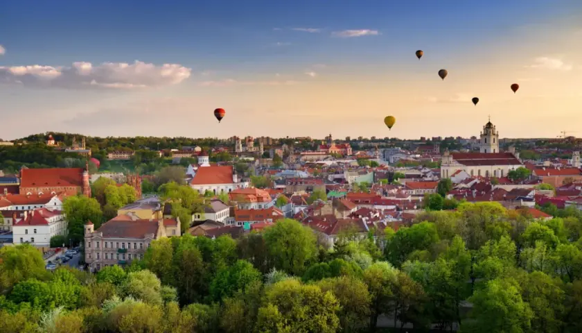 Widok na Wilno z lotu ptaka, z kilkoma balonami na gorące powietrze na niebie.