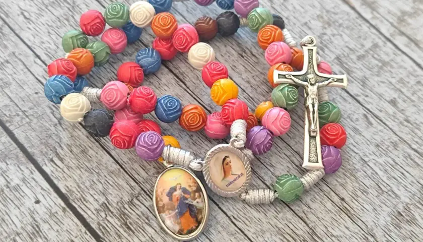 Kolorowy różaniec z medalikami i krzyżem, idealny do modlitwy do Matki Bożej Rozwiązującej Węzły.