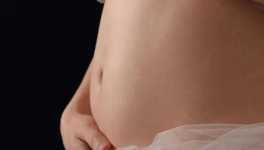 Primo piano di una pancia in gravidanza, che mostra la sua crescita settimana per settimana.