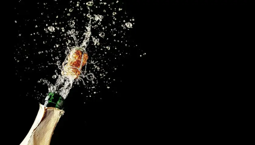 Champagnerkorken spritzt mit Flüssigkeit aus einer Flasche. Perfekt für den Moment, wenn man Champagner lagern und dann genießen möchte.