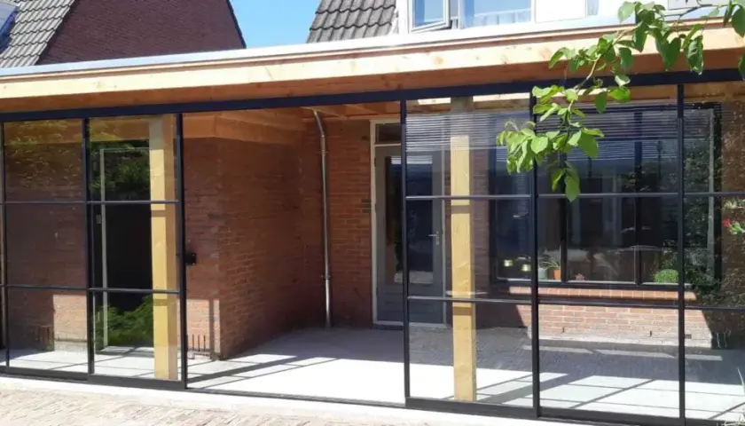 Neues Flachdach-Anbaudach mit Stahlrahmenfenstern. Ein schönes Projekt, um das eigene Dach selber bauen zu können.