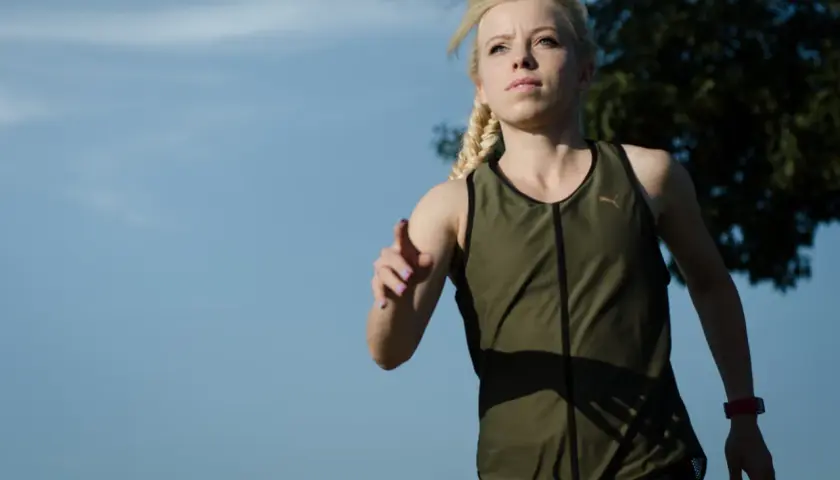 Zdeterminowana biegaczka z warkoczem, gotowa na wyzwanie, jak przebiec 10 km.