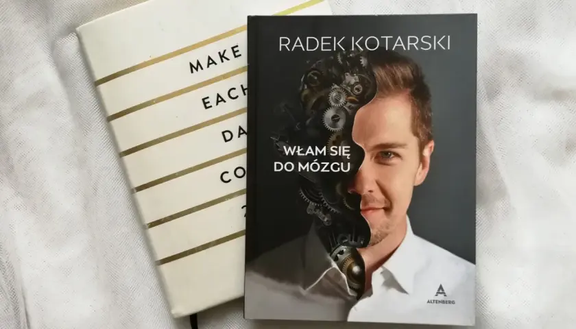 Okładka książki "Włam się do mózgu" Radka Kotarskiego, obok notatnika. Czy warto wprowadzać wątek romantyczny do twardego science-fiction?