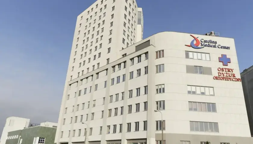 Nowoczesny budynek Carolina Medical Center w Warszawie z napisem "Ostry Dyżur Ortopedyczny".