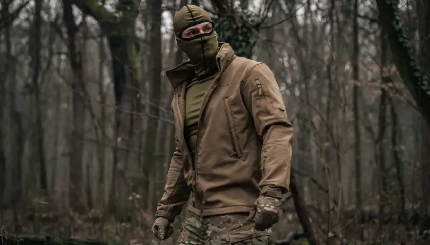 Mężczyzna w lesie, ubrany w kurtkę i maskę, nosi bieliznę termoaktywną Helikon.
