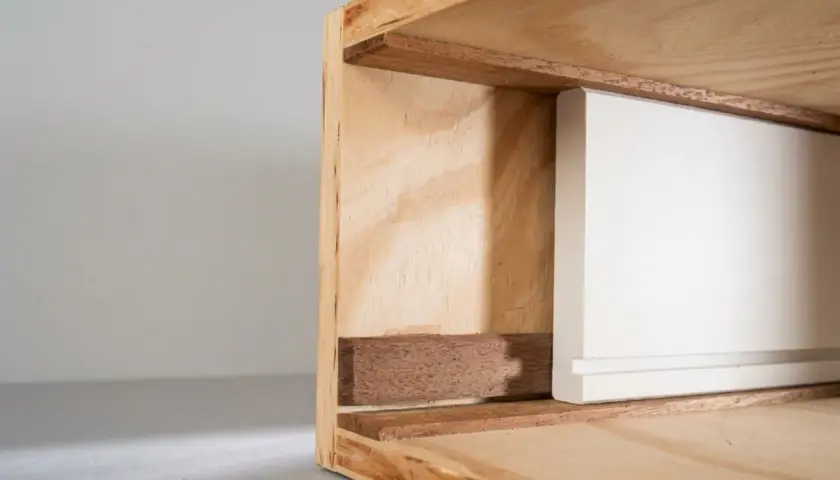 Detailaufnahme einer weißen Schubladenfront, die in einen Holzrahmen gleitet. Perfekt, wenn Sie eine Schublade selber bauen möchten.