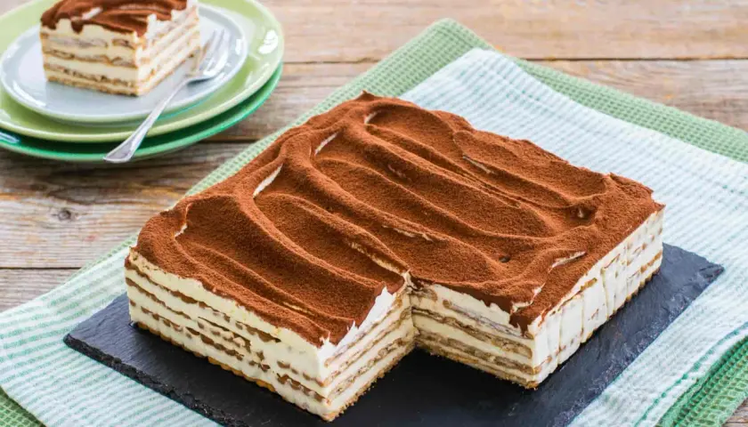 Un invitante tiramisù con oro Saiwa, stratificato e cosparso di cacao, pronto per essere gustato.
