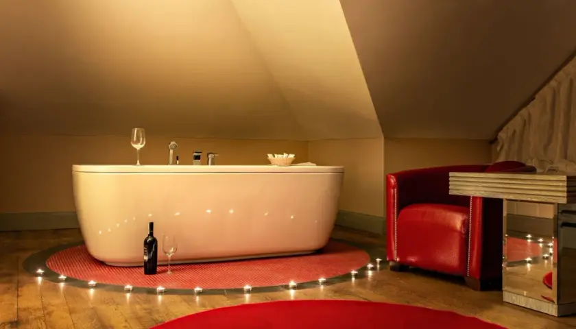 Romantyczny weekend w Kazimierzu Dolnym dla dwojga: wanna, świece, wino i czerwony fotel tworzą idealną atmosferę.
