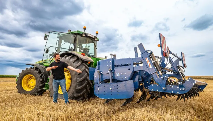 Un homme présente une charrue Rolmako, un outil agricole essentiel pour préparer les sols. La sep charrue définition est ici illustrée par cet équipement robuste.