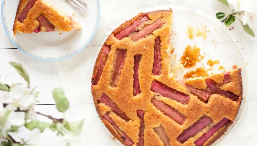 Wilgotne ciasto z rabarbarem, udekorowane świeżymi gałązkami kwitnącej jabłoni. Idealne na wiosenne popołudnie.